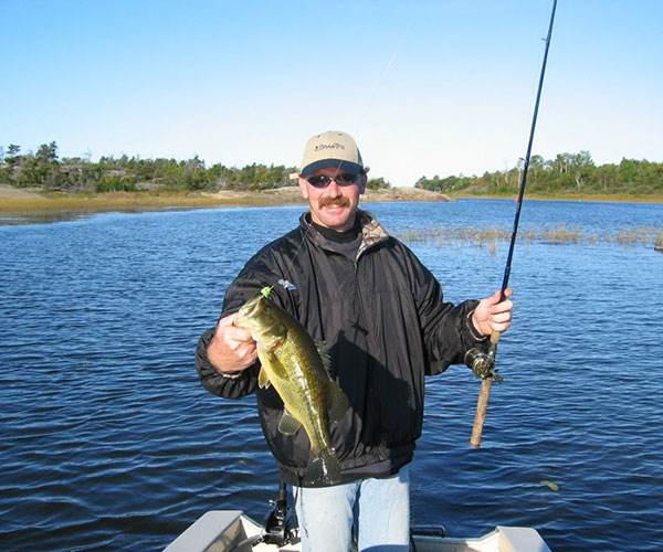 Key Marine Resort guest holding a fish on a boat.